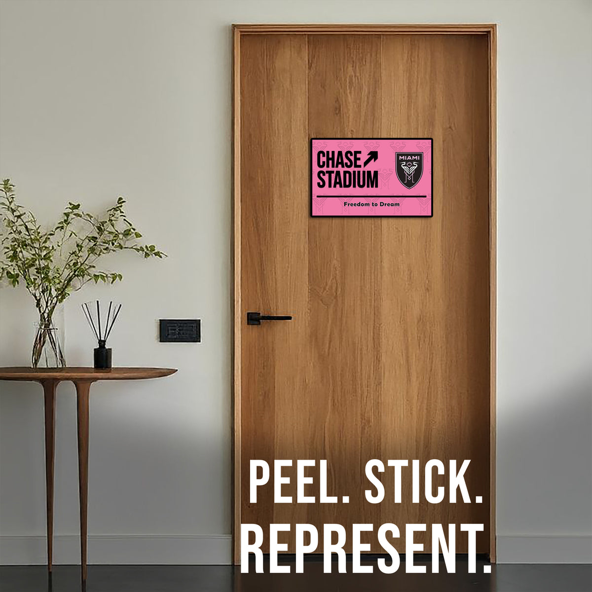Wooden door with a pink and black sign labeled 'Chase Stadium' and text 'Peel. Stick. Represent.'.