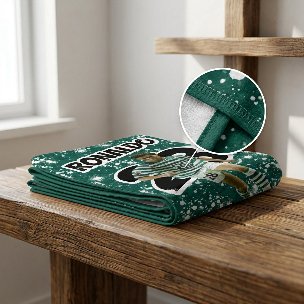 Folded green blanket with branding on a wooden surface, close-up of texture.