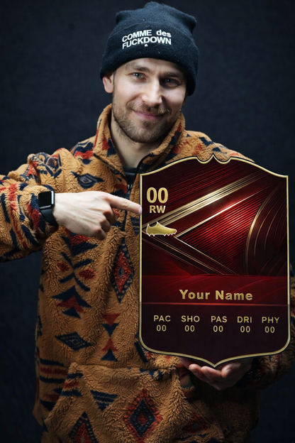 Person wearing a patterned jacket and beanie, holding a decorative plaque with text and graphics.
