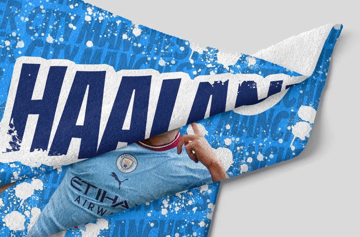 Blue and white sports towel with 'HAAHN' branding on a gray background