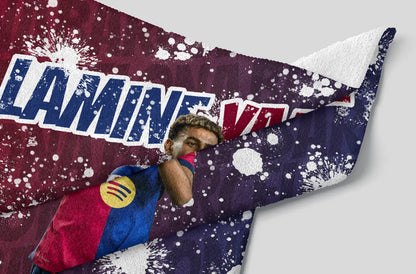 Person lying on a colorful blanket with 'Lamine' printed on it
