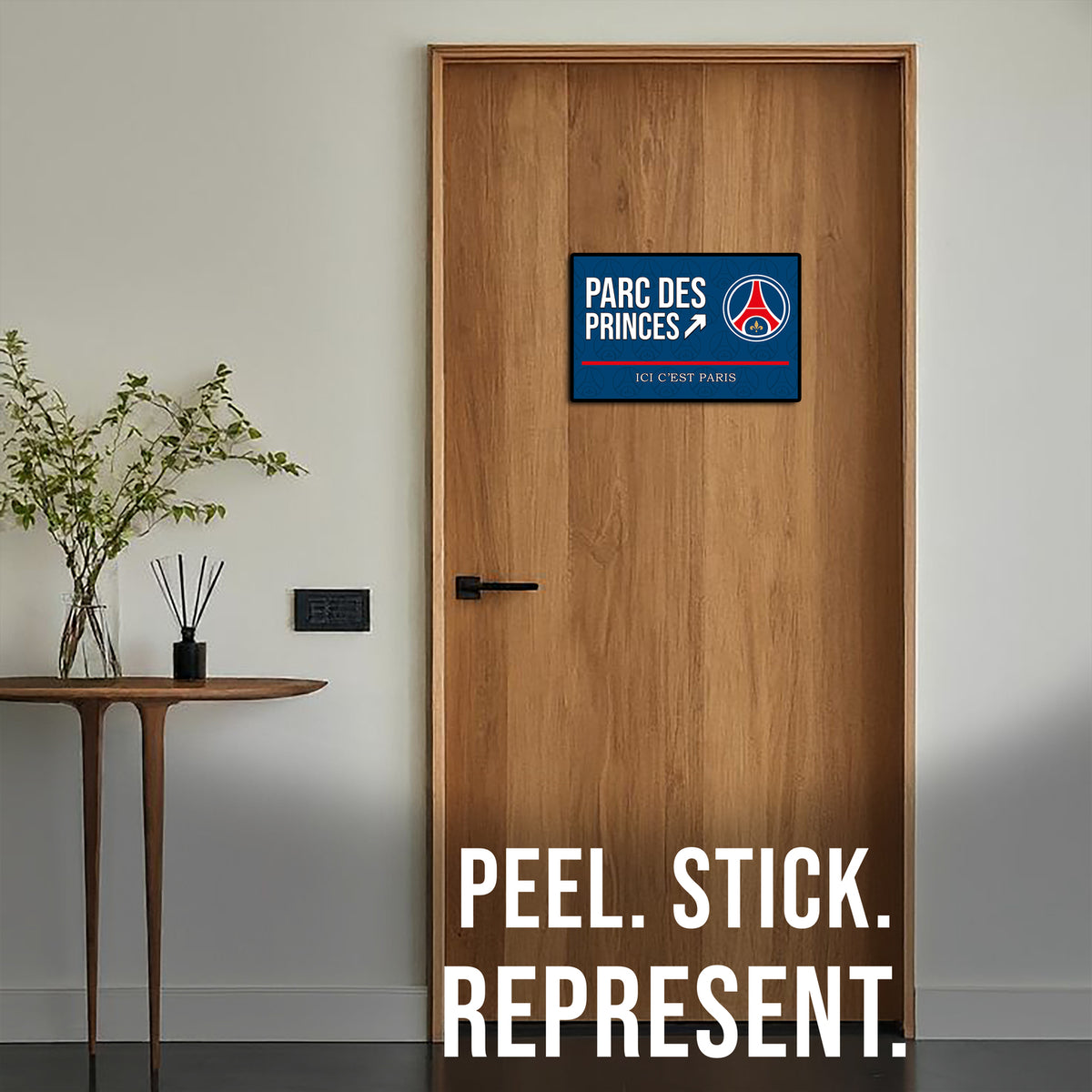 Wooden door with a decorative sticker and text 'Parc des Princes' on a neutral background.