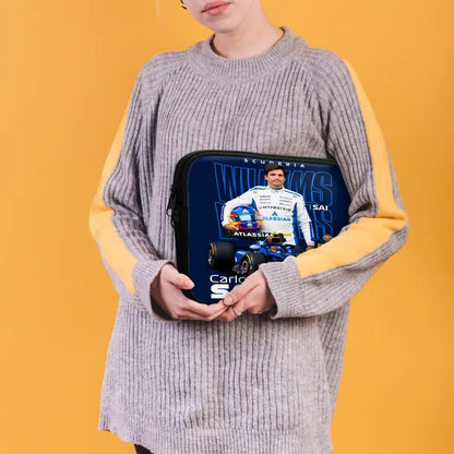 Person holding a laptop case with a racing driver design on an orange background