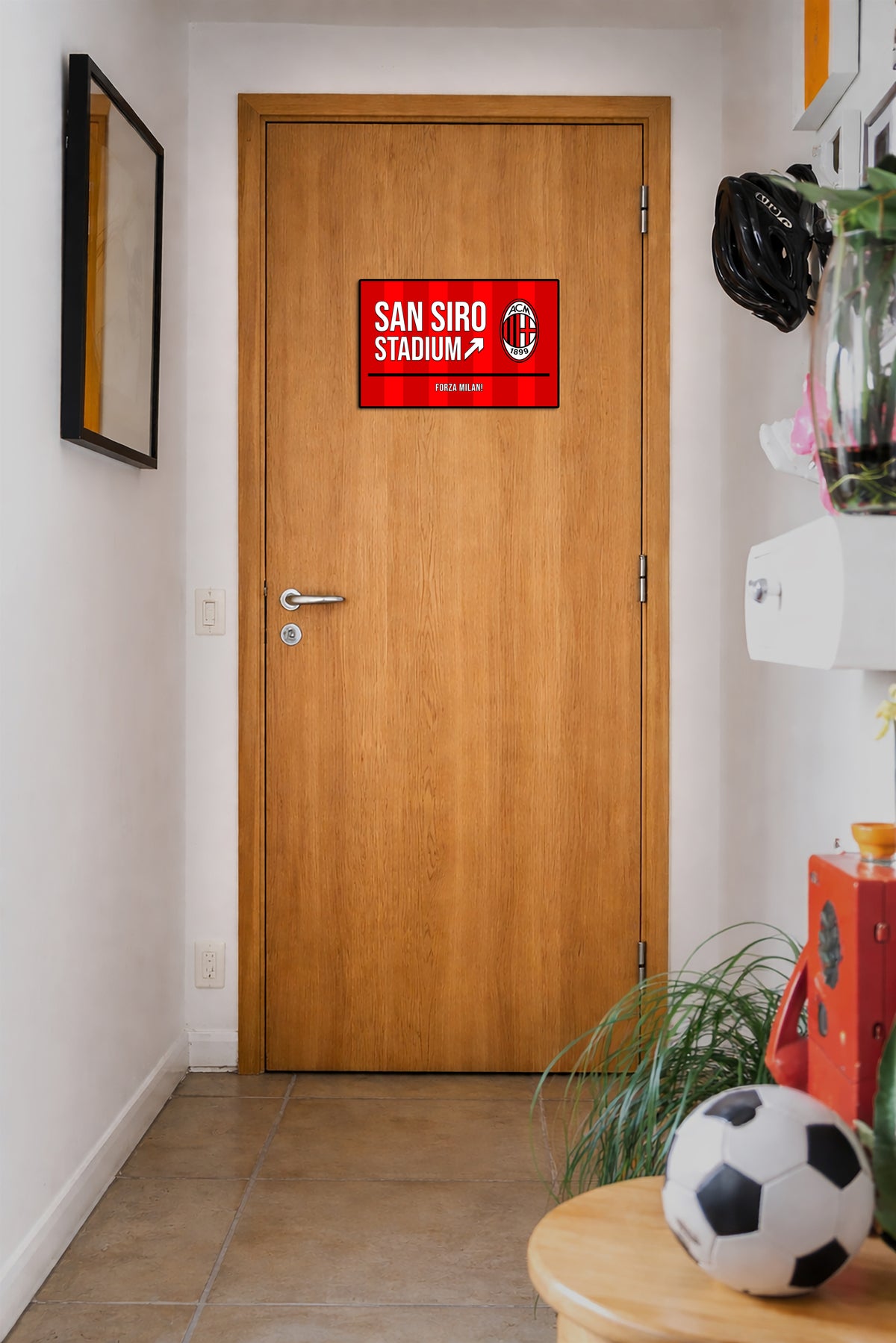 Wooden door with a red sign labeled 'San Siro Stadium' in a hallway.