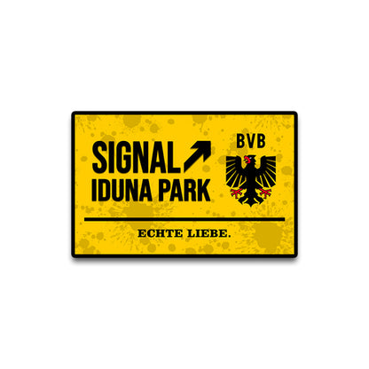 Yellow sign with 'Signal Iduna Park' and BVB logo on a white background